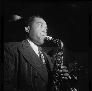 Charlie Parker: Portrait of Charlie Parker in the Three Deuces of New York (N.Y.), in August 1947. Parker is playing a Conn 6M alto saxophone. Standing next to him is Miles